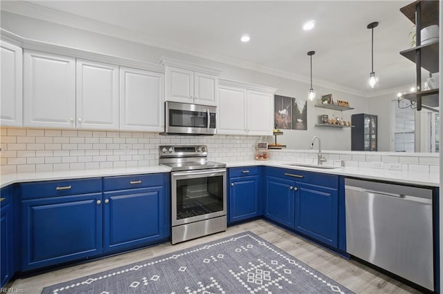 kitchen featuring appliances with stainless steel finishes, a sink, light wood-style flooring, and blue cabinets
