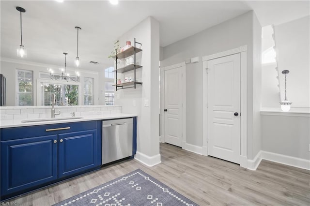 kitchen with a notable chandelier, a sink, dishwasher, blue cabinetry, and baseboards