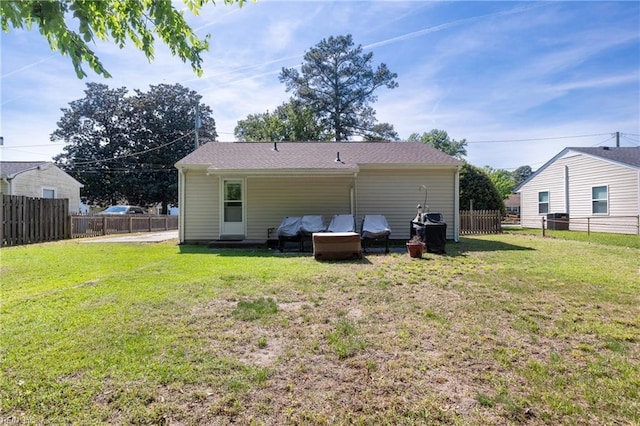 rear view of property featuring a lawn and fence private yard