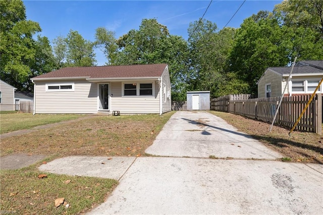 bungalow-style home featuring fence, entry steps, concrete driveway, and a front yard