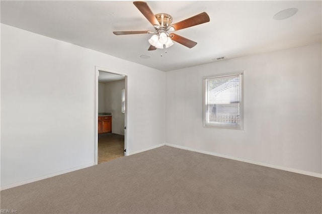 empty room featuring baseboards, a ceiling fan, carpet, and visible vents