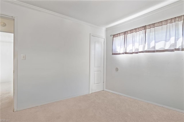 unfurnished room featuring baseboards, ornamental molding, and carpet