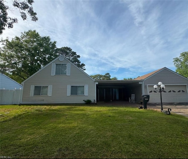exterior space with an attached garage, a front lawn, fence, and driveway