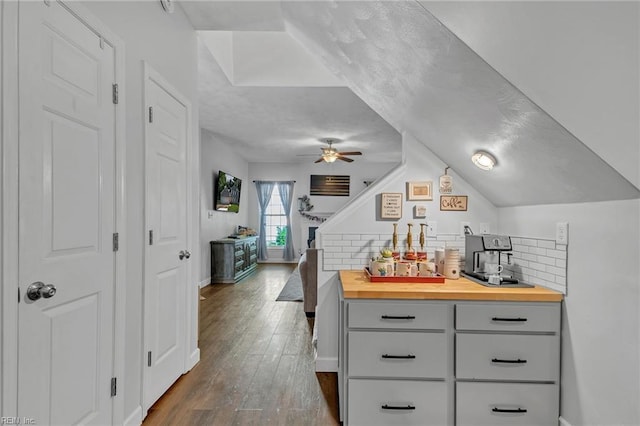 kitchen featuring wood counters, gray cabinets, backsplash, and dark wood-style floors