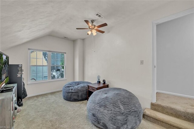 living area with ceiling fan, visible vents, carpet floors, baseboards, and lofted ceiling