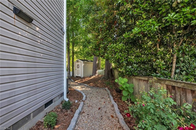 view of yard with a storage unit, fence, and an outbuilding