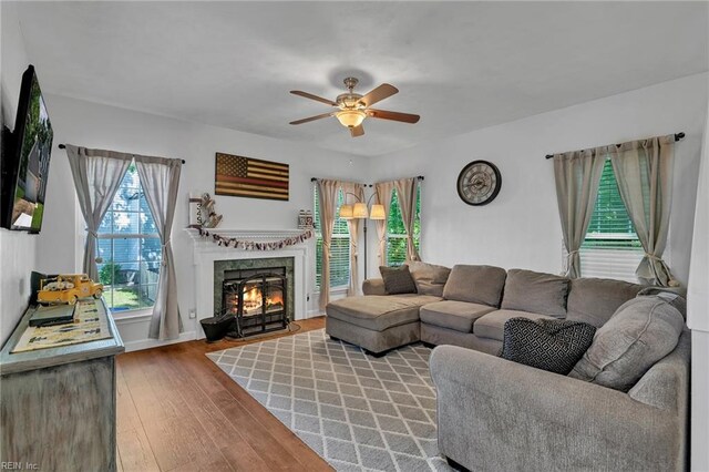 living area with ceiling fan, wood finished floors, and a high end fireplace