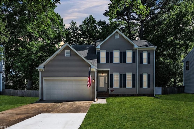 colonial inspired home featuring fence, an attached garage, driveway, and a front yard