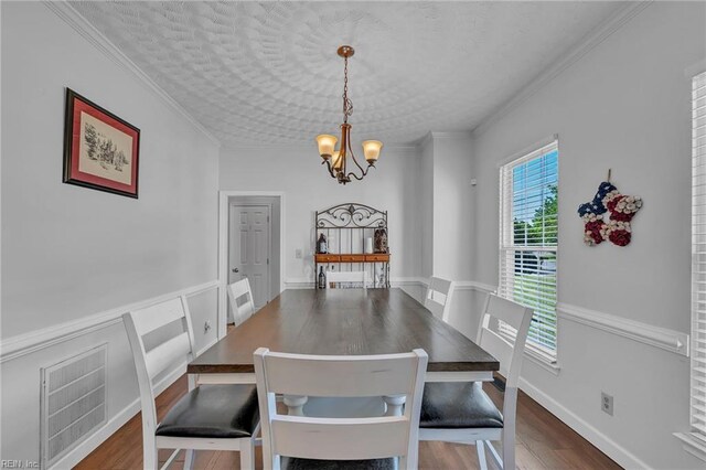 dining space featuring an inviting chandelier, dark wood-style floors, ornamental molding, and visible vents