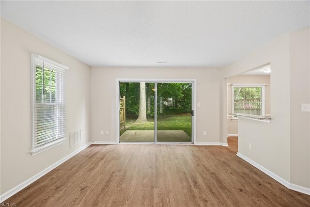 empty room with visible vents, baseboards, and wood finished floors