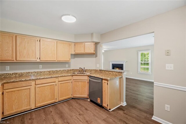 kitchen featuring light stone counters, a sink, light brown cabinets, dishwasher, and dark wood-style floors