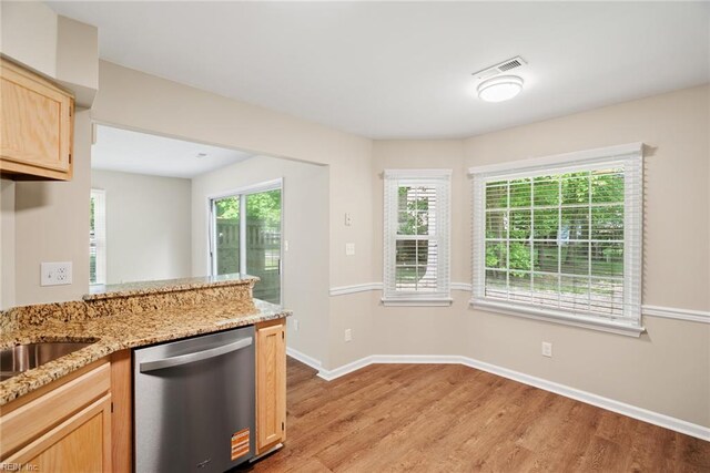 kitchen featuring stainless steel dishwasher, light wood-style flooring, visible vents, and a wealth of natural light