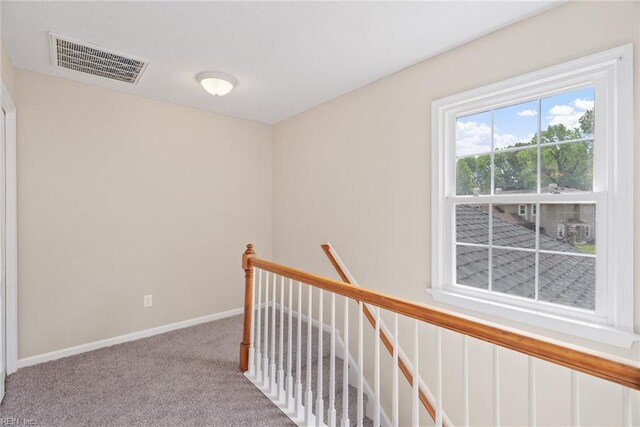 hallway with baseboards, an upstairs landing, carpet flooring, and visible vents