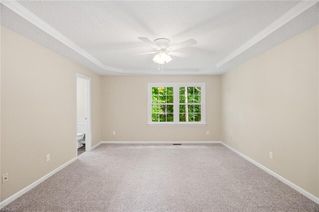 unfurnished room with carpet flooring, a ceiling fan, a textured ceiling, and a raised ceiling