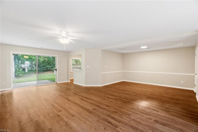empty room featuring baseboards, a ceiling fan, and wood finished floors