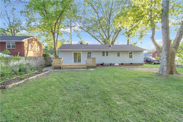 back of property featuring fence, a wooden deck, a yard, and crawl space