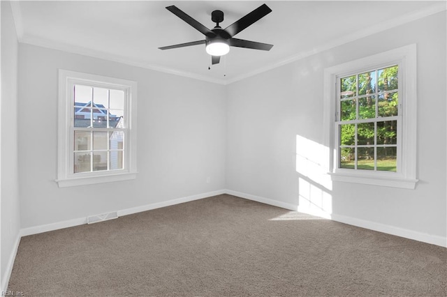 unfurnished room featuring a healthy amount of sunlight, ornamental molding, and visible vents