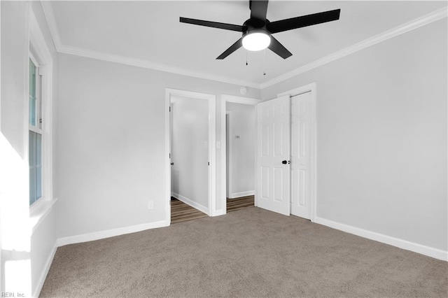unfurnished bedroom featuring carpet flooring, a ceiling fan, baseboards, and ornamental molding