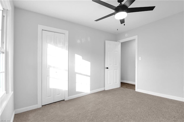 unfurnished bedroom featuring carpet floors, baseboards, and a closet