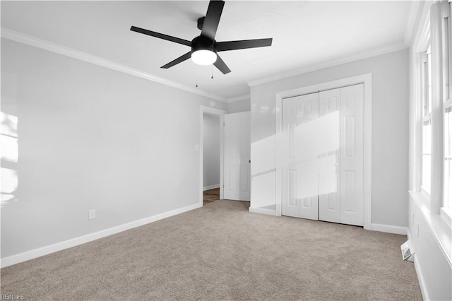 unfurnished bedroom with crown molding, carpet, baseboards, and a closet