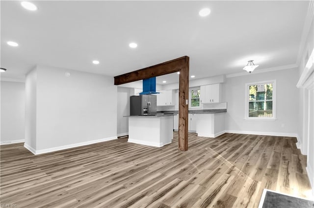 unfurnished living room featuring crown molding, recessed lighting, baseboards, and light wood-style floors