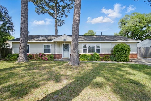 ranch-style house featuring fence, a front yard, and brick siding