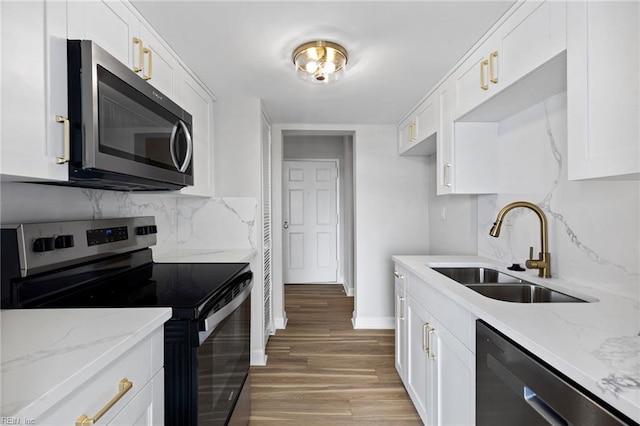 2830 Shore Dr Unit 405, Virginia Beach, VA 23451 - kitchen featuring decorative backsplash, white cabinets, a sink, light wood finished floors, and stainless steel appliances