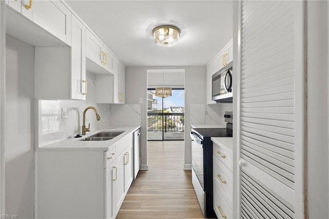 2830 Shore Dr Unit 405, Virginia Beach, VA 23451 - kitchen featuring tasteful backsplash, white cabinetry, a sink, stainless steel appliances, and light wood-style flooring