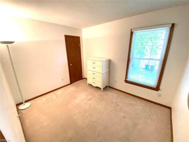 unfurnished bedroom with baseboards and light carpet