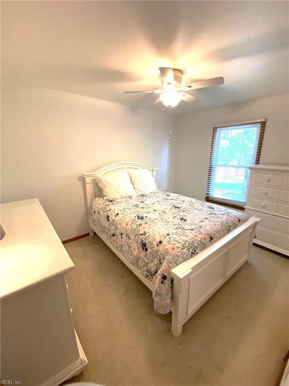 bedroom with light colored carpet, baseboards, and ceiling fan
