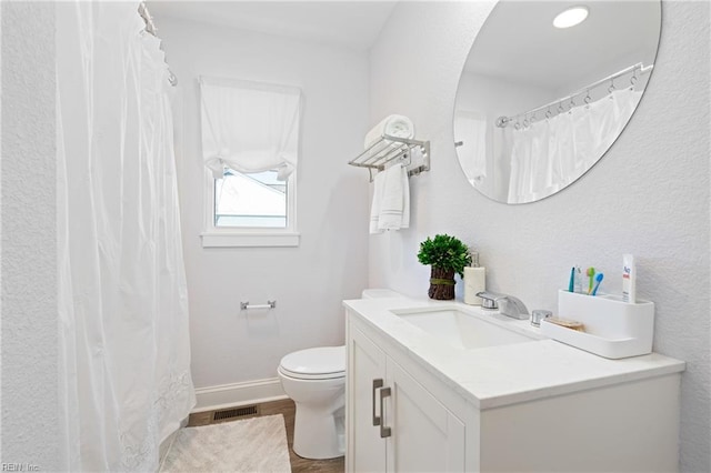 bathroom with toilet, baseboards, visible vents, and vanity