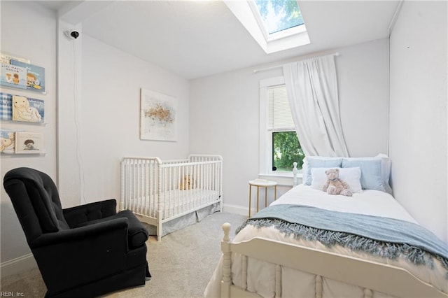 bedroom with carpet flooring, a skylight, and baseboards