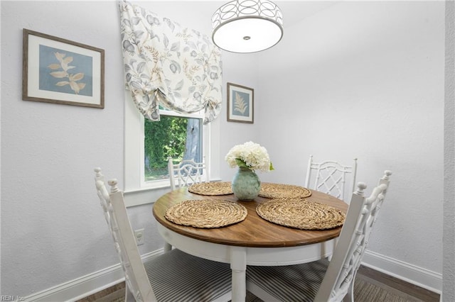 dining space featuring baseboards and wood finished floors