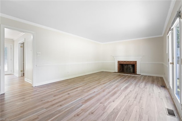 unfurnished living room with light wood-style floors, baseboards, a brick fireplace, and visible vents