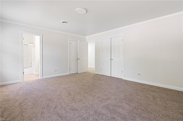 carpeted spare room with crown molding and baseboards