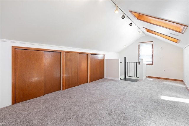 additional living space featuring baseboards, carpet, and vaulted ceiling with skylight