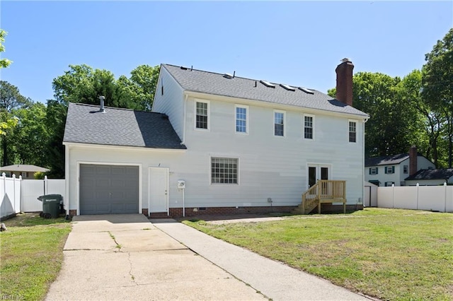 back of house with an attached garage, fence, a chimney, and driveway