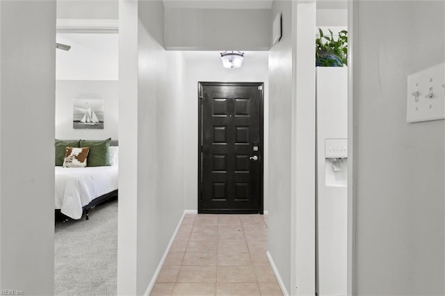 corridor with baseboards and light tile patterned floors