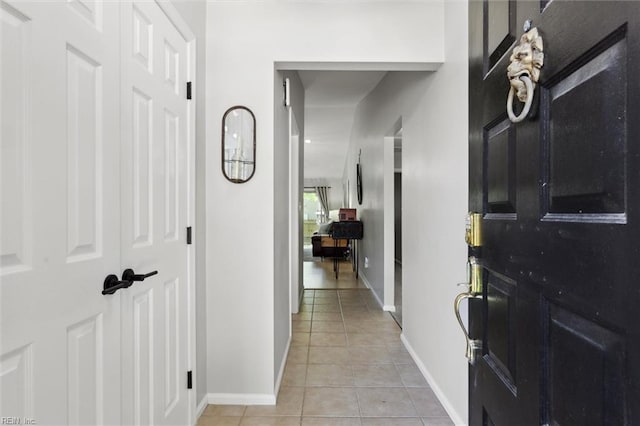 corridor with baseboards and light tile patterned floors
