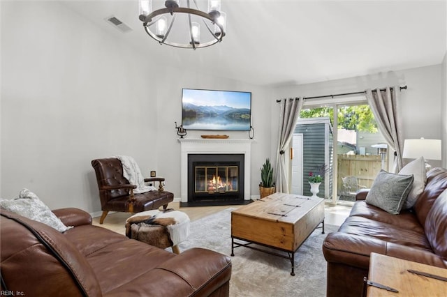 living room with baseboards, a notable chandelier, a fireplace with flush hearth, and visible vents
