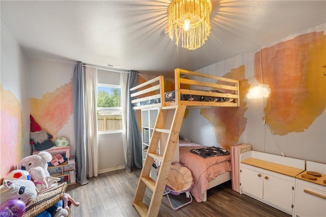 bedroom with an inviting chandelier and wood finished floors
