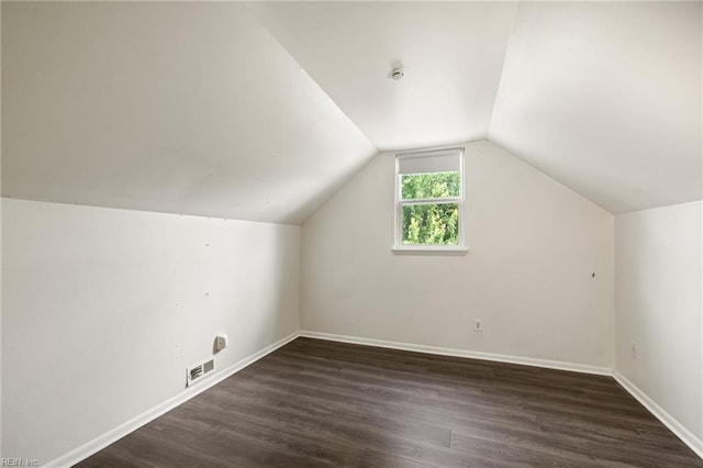 bonus room with baseboards, lofted ceiling, wood finished floors, and visible vents