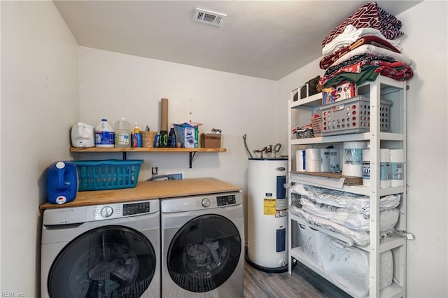 washroom featuring laundry area, visible vents, wood finished floors, water heater, and washer and dryer