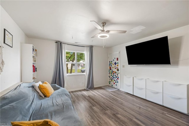 bedroom with a ceiling fan, baseboards, and wood finished floors
