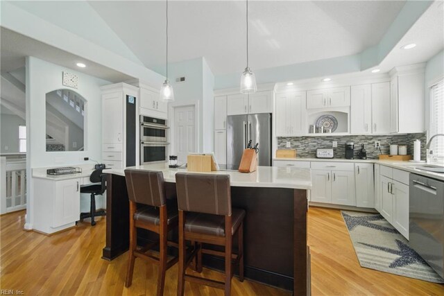 828 Vanderbilt Ave, Virginia Beach, VA 23451 - kitchen with decorative backsplash, white cabinets, appliances with stainless steel finishes, and vaulted ceiling