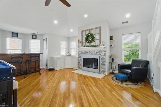 828 Vanderbilt Ave, Virginia Beach, VA 23451 - living area with ceiling fan, a tiled fireplace, a healthy amount of sunlight, light wood-type flooring, and visible vents