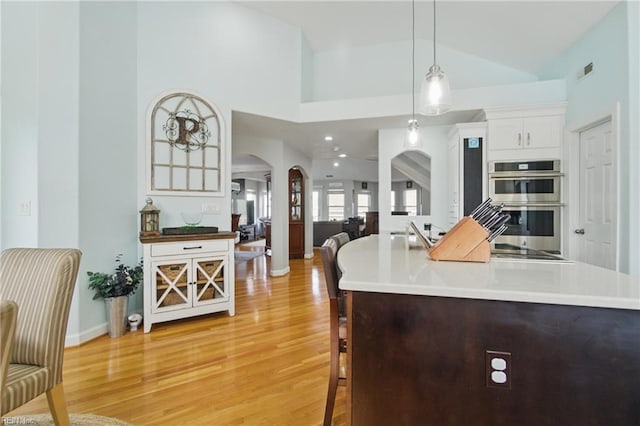 828 Vanderbilt Ave, Virginia Beach, VA 23451 - kitchen with visible vents, double oven, arched walkways, light wood finished floors, and decorative light fixtures