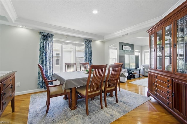 828 Vanderbilt Ave, Virginia Beach, VA 23451 - dining space with crown molding, arched walkways, a textured ceiling, and light wood-style floors
