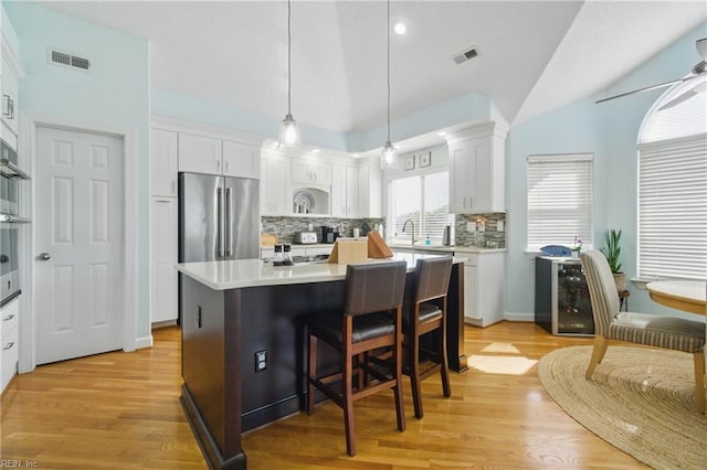 828 Vanderbilt Ave, Virginia Beach, VA 23451 - kitchen with backsplash, white cabinetry, high end fridge, and visible vents