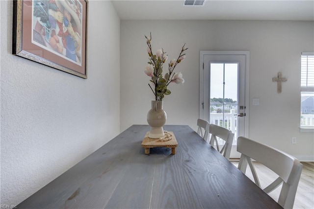 dining space with wood finished floors and visible vents
